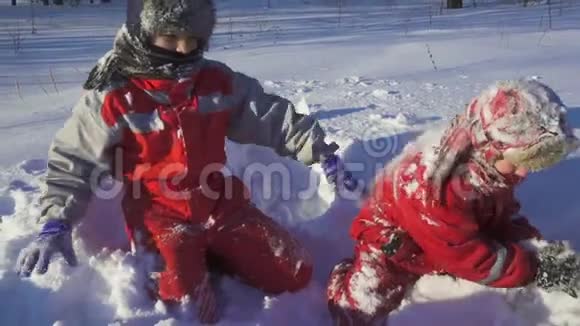两个孩子一起玩在冬天的公园里扔雪视频的预览图