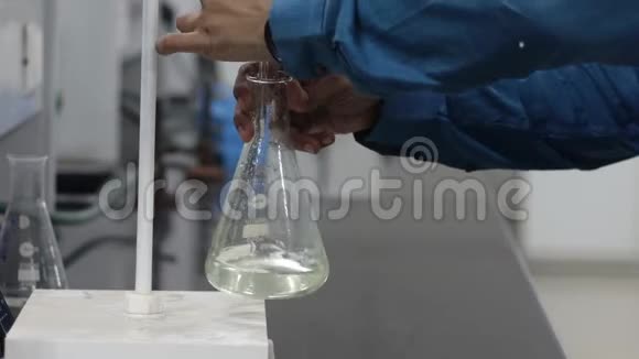 滴定管在锥形瓶中摇动无色液体的滴定反应视频的预览图