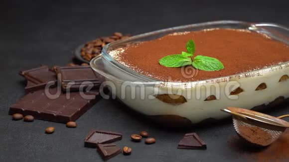 玻璃烤盘中的提拉米苏甜点和混凝土背景上的巧克力块视频的预览图