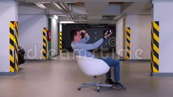 那家伙坐在车库的一张白色椅子上旋转视频的预览图