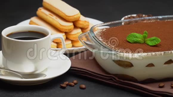 玻璃烤盘中的提拉米苏甜点浓缩咖啡杯和混凝土背景下的萨维亚迪视频的预览图