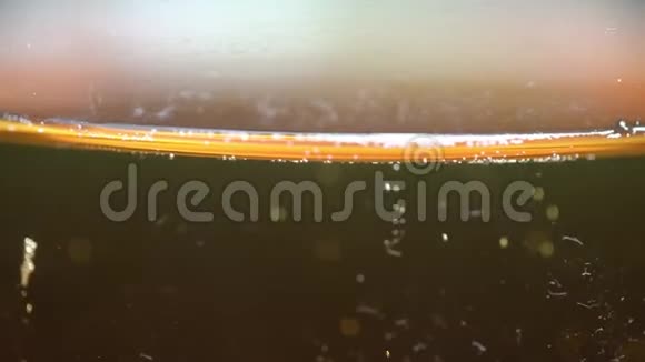 小啤酒泡沫泡沫从液体上升到玻璃顶部视频的预览图
