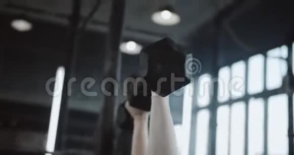 特写年轻漂亮的白种人红头发运动妇女举哑铃躺在大型专业健身房的长凳上视频的预览图