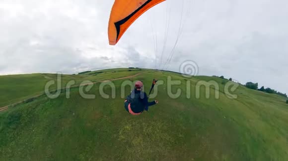 人驾驶滑翔伞降落在地上视频的预览图