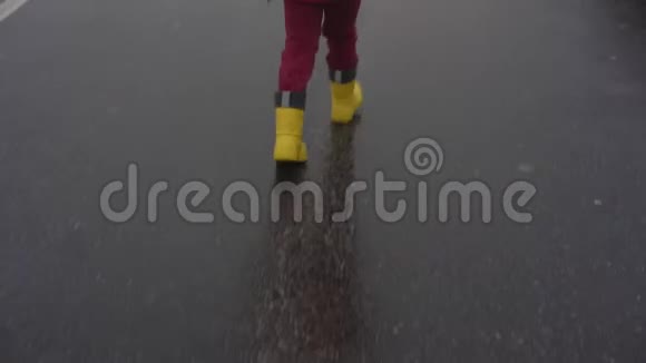 穿着红色裤子和黄色防水橡胶靴的儿童腿视频的预览图