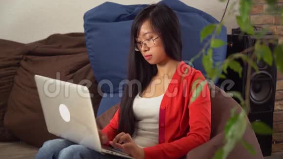 肖像年轻的亚洲女孩微笑着看着相机在网上聊天视频的预览图