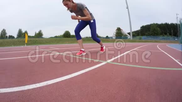 一位年轻漂亮的女运动员穿着红色短裙在一天的跑步训练中跑过镜头视频的预览图