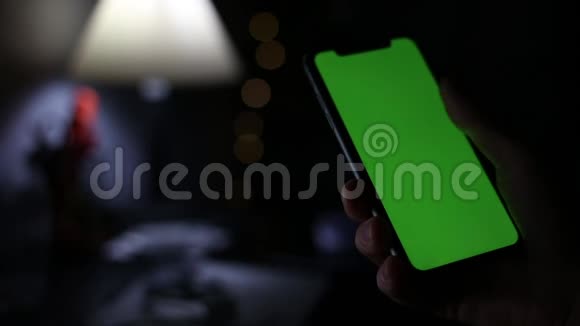 用绿色屏幕特写男性手握智能手机视频的预览图