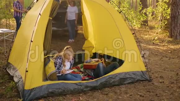 十几岁的女孩在露营帐篷里拿着吉他少女在旅游帐篷里用吉他演奏音乐视频的预览图