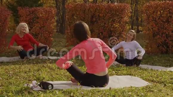 在秋林的瑜伽地毯上放松的女人冥想莲花姿势瑜伽女性通过冥想音乐放松视频的预览图