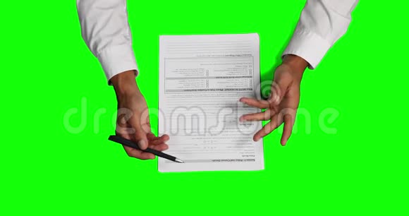 一名白人男子用绿色屏幕解释一份文件的俯视图视频的预览图