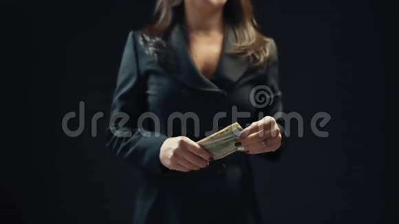 关门年轻的女商人扔钱黑色背景慢动作视频的预览图
