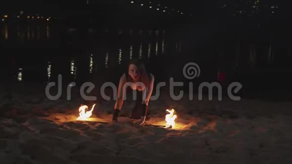 从沙子里举起燃烧的火把的女性视频的预览图