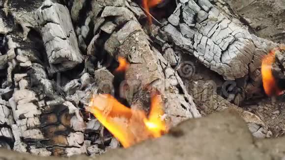 在舒适的砖制壁炉氛围中用橙色火焰缓慢燃烧的木头上拍摄的非常令人满意的特写镜头视频的预览图