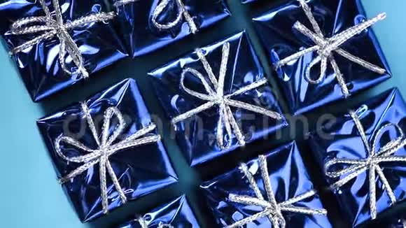 蓝色背景上移动蓝色礼品盒圣诞节和新年的旋转背景现在惊喜的概念视频的预览图
