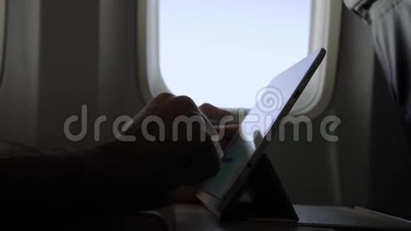 男性在飞机上使用现代数字平板电脑视频的预览图
