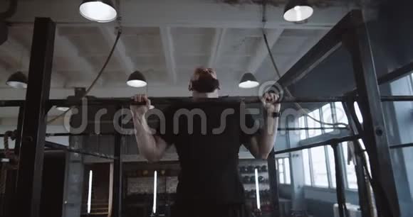 年轻英俊肌肉发达的高加索人在健身房慢动作的极限锻炼中跳起来休息视频的预览图