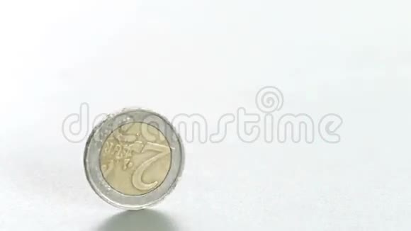 两枚欧元硬币在白色表面缓慢旋转视频的预览图