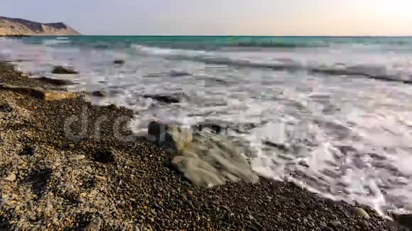 时间推移波浪在一个海洋卵石景观上滚动背景是一座山视频的预览图
