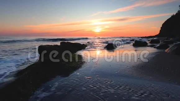 海滩上的海上日出岸上的岩石视频的预览图