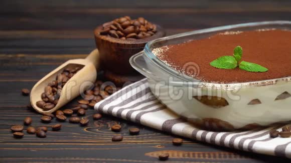 传统意大利提拉米苏甜点玻璃烤盘和咖啡豆木制背景视频的预览图