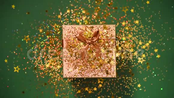 闪闪发光的金色星星绿色背景上的礼品盒上闪闪发光的纸屑上景圣诞节和新年的质地视频的预览图