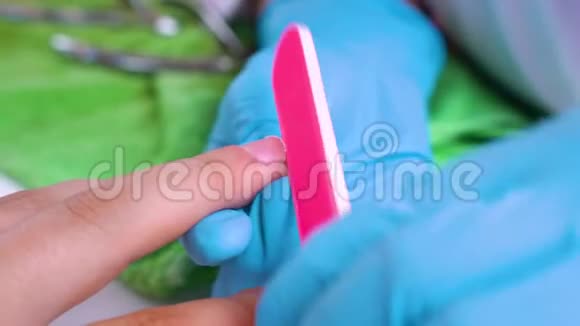 医生在水疗沙龙里给一个男人锯了一个粉红色的指甲文件指甲护理男性的魅力视频的预览图