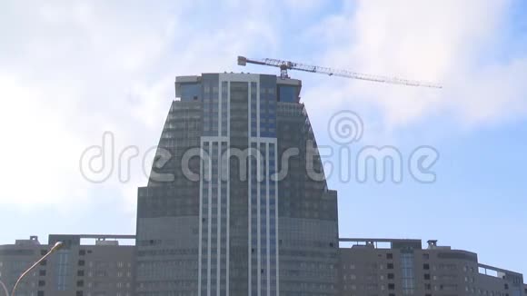 在高层建筑中塔式起重机建造了一座摩天大楼背景是云和飞机飞行快速射击和时间跳跃视频的预览图