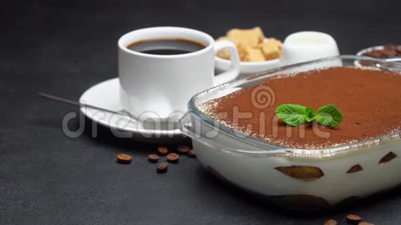 玻璃烤盘中的提拉米苏甜点和混凝土背景下的一杯浓咖啡视频的预览图