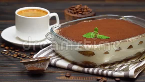 玻璃烤盘中的提拉米苏甜点和木制背景的新鲜热浓咖啡视频的预览图