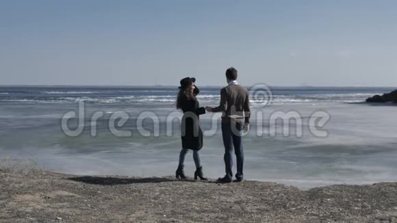 年轻的一对夫妇双手相拥沙丘下阳光明媚的春天视频的预览图