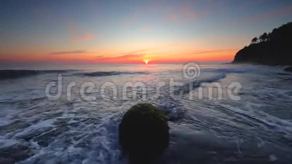 海滩上的海上日出岸上的岩石视频的预览图