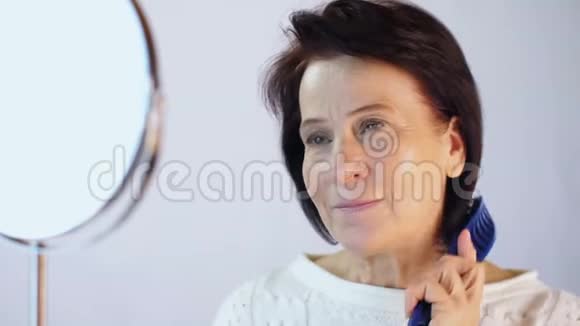 镜前梳头的老年妇女视频的预览图