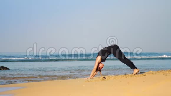 穿运动服的女孩在海边做普拉提运动视频的预览图