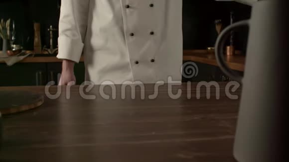 男厨师在厨房桌子上放面粉慢动作做饭视频的预览图