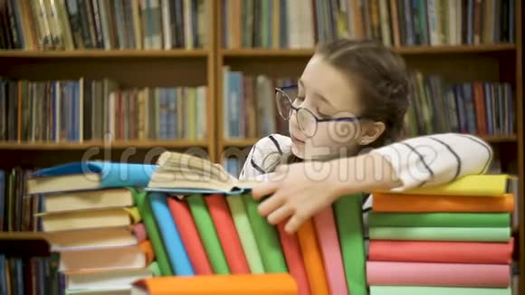 戴眼镜的女孩在图书馆翻阅一本书视频的预览图