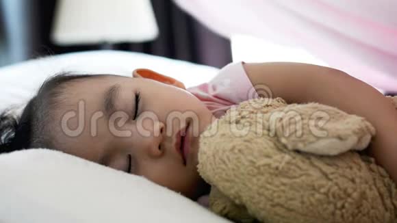 闭上可爱的亚洲女婴睡在床上妈妈给婴儿放毯子侧视图视频的预览图