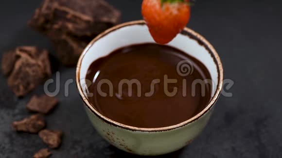 把草莓浸在融化的黑巧克力里视频的预览图
