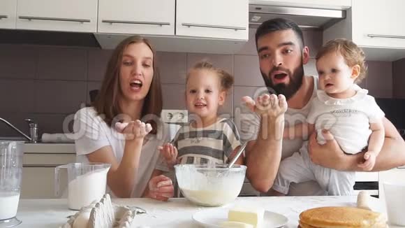 有趣的家庭在厨房里玩父母和孩子吹面粉视频的预览图