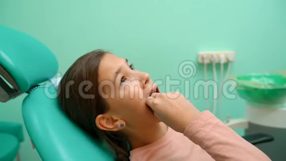 那个女孩躺在牙科椅上摇着他的坏牙视频的预览图