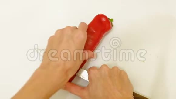 家庭主妇用刀切红辣椒隔离顶部视频的预览图