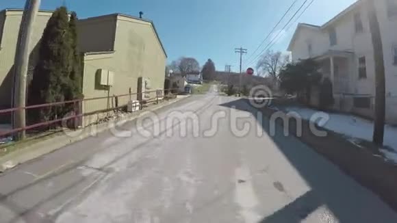 在阳光明媚的下午一辆汽车在北美小镇的十字路口刹车视频的预览图