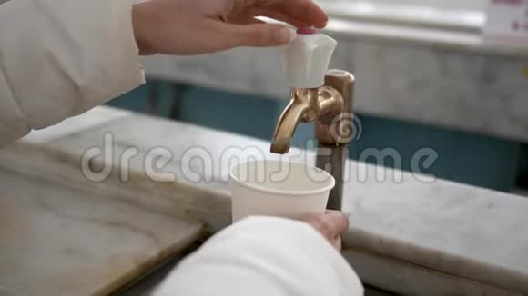 纸杯中妇女倒矿泉水的起重机和手的特写视频的预览图