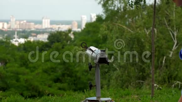 微笑的女孩欣赏城市风景望着灰色望远镜视频的预览图