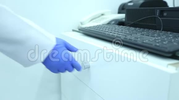 实验室技术人员穿着白色的实验室外套和蓝色的乳胶手套从抽屉里拿出试管视频的预览图