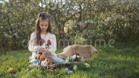 这个女孩用彩色鸡蛋灰色复活节兔子装饰视频的预览图