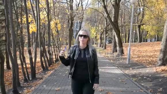 在秋天公园的一条小径上跳舞的小径上跳舞视频的预览图