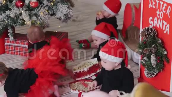 小婴儿坐在地毯上玩圣诞礼物一个男孩在哭视频的预览图
