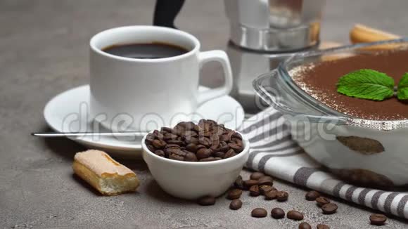 玻璃烤盘中的提拉米苏甜点浓缩咖啡杯和混凝土背景下的摩卡咖啡机视频的预览图