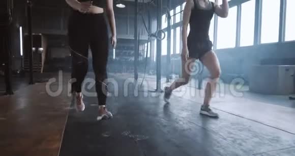 慢动作两个年轻漂亮的运动欧洲妇女一起工作在大气健身房做有氧运动视频的预览图